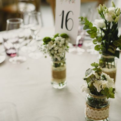 Centerpieces in a wedding hall, floral decorations photographed during the day.